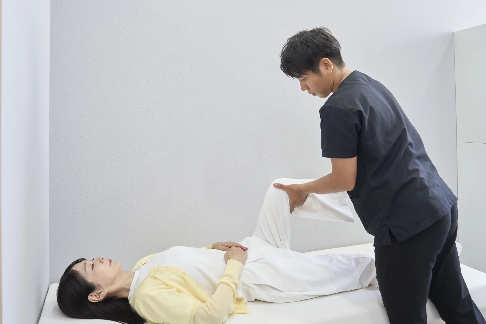 医師が患者さまの股関節と脚の動きを確認する様子