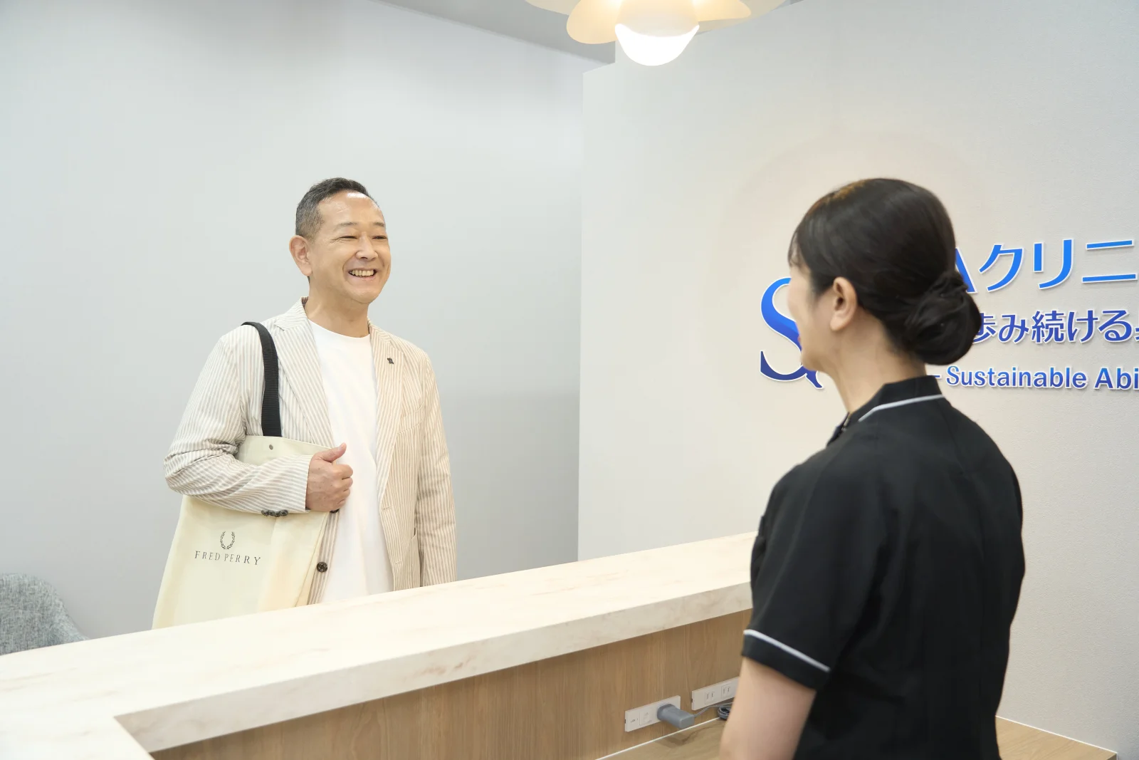 患者さまが院内でスタッフと笑顔で相談する様子