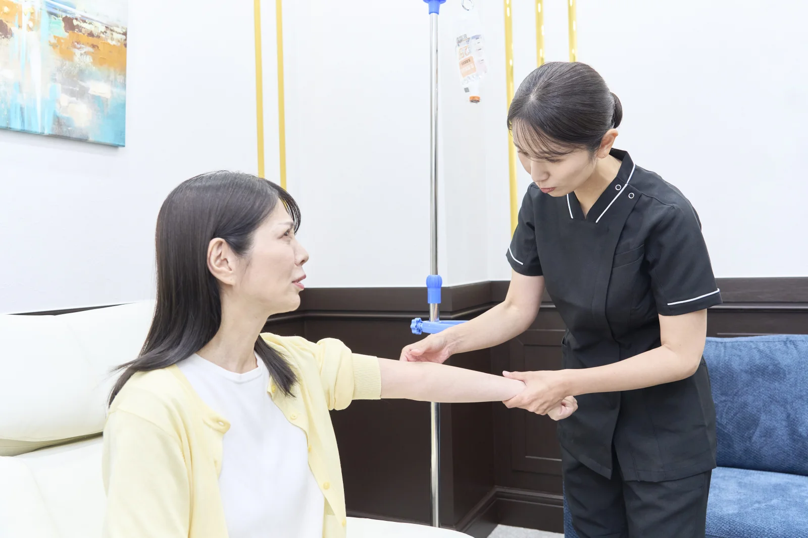 スタッフが患者さまの腕を支えながらリハビリを行う様子
